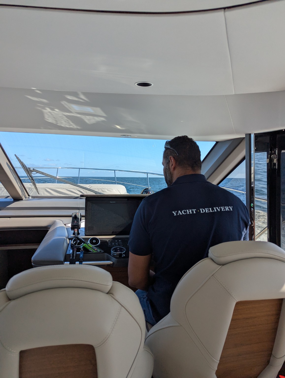 Delivery captain in a Yacht.Delivery shirt at the helm of a Princess F65 under way at sea