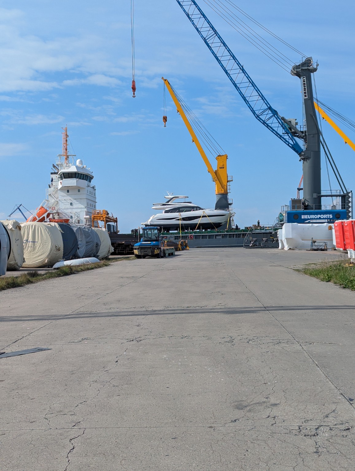Princess F65 motor yacht secured on the deck of a cargo vessel alongside a commercial quay
